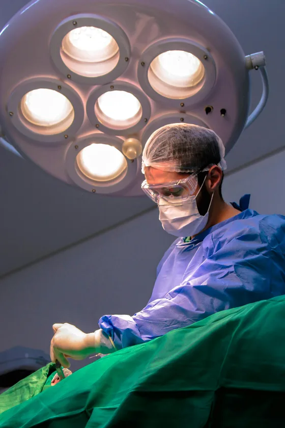 Chirurg im OP-Saal unter OP-Leuchten